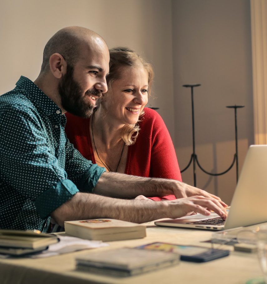 A man and a woman in front of a laptop