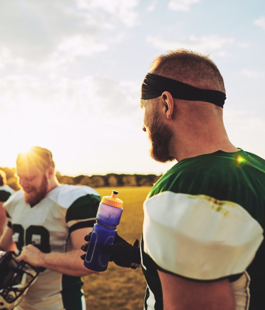 American football players talking together on field after practice