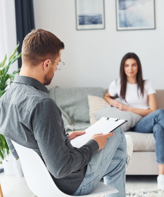 Young woman at a reception at a psychologist. Sits on the sofa